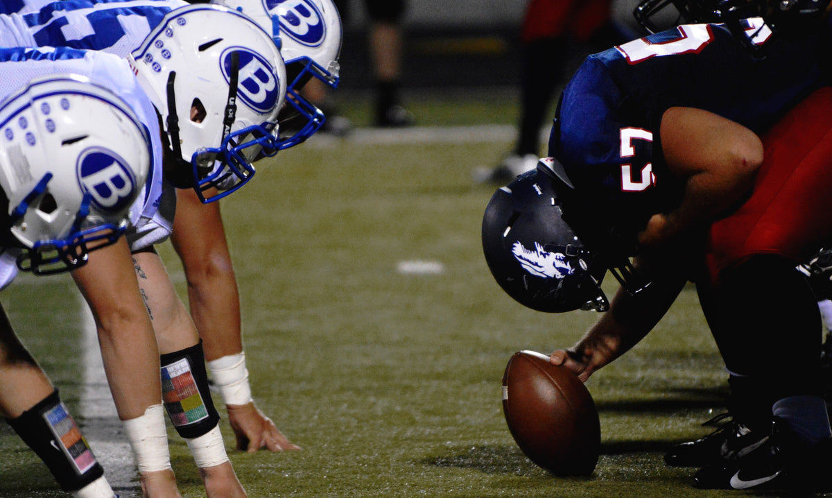 Linemen set at the line of scrimmage as the center grips the ball before the snap